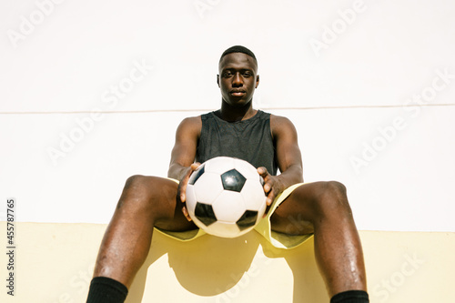 Black football player resting during training photo