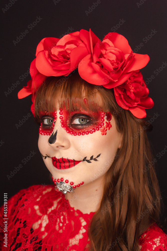 Portrait detail of the face of a beautiful happy girl with Day of the Dead makeup on black background. Portrait detail of the face of a beautiful happy girl with Day of the Dead makeup on black background.