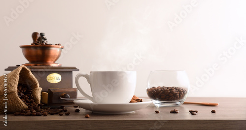 Cup coffee sack and grinder on wooden table isolated background