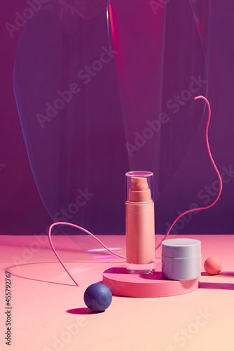 Pink plastic tube for cosmetics on the podium photo