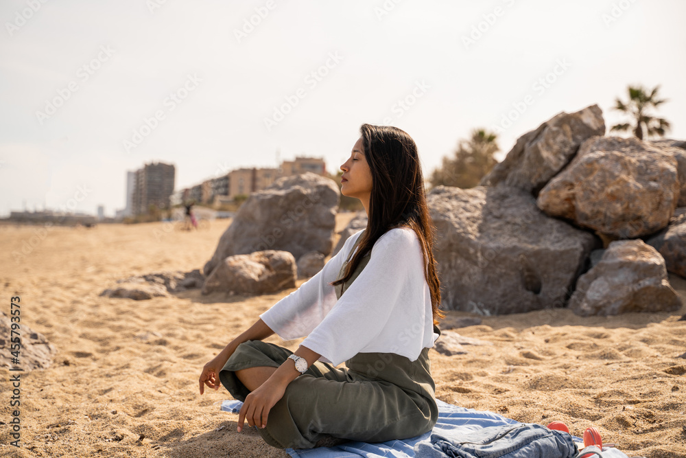 Beautiful young woman sitting relaxing at beach Beautiful young woman sitting relaxing at beach