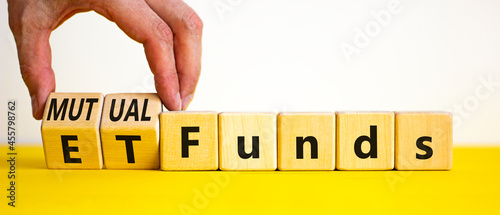 Mutual funds vs ETF symbol. Businessman turns cubes and changes words 'ETF, Exchange-Traded Fund' to 'Mutual funds. Beautiful white background, copy space. Business and ETF vs mutual funds concept. photo