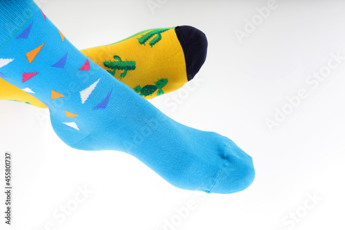 Obraz na płótnie Legs with different a pair of mismatched socks on white background
