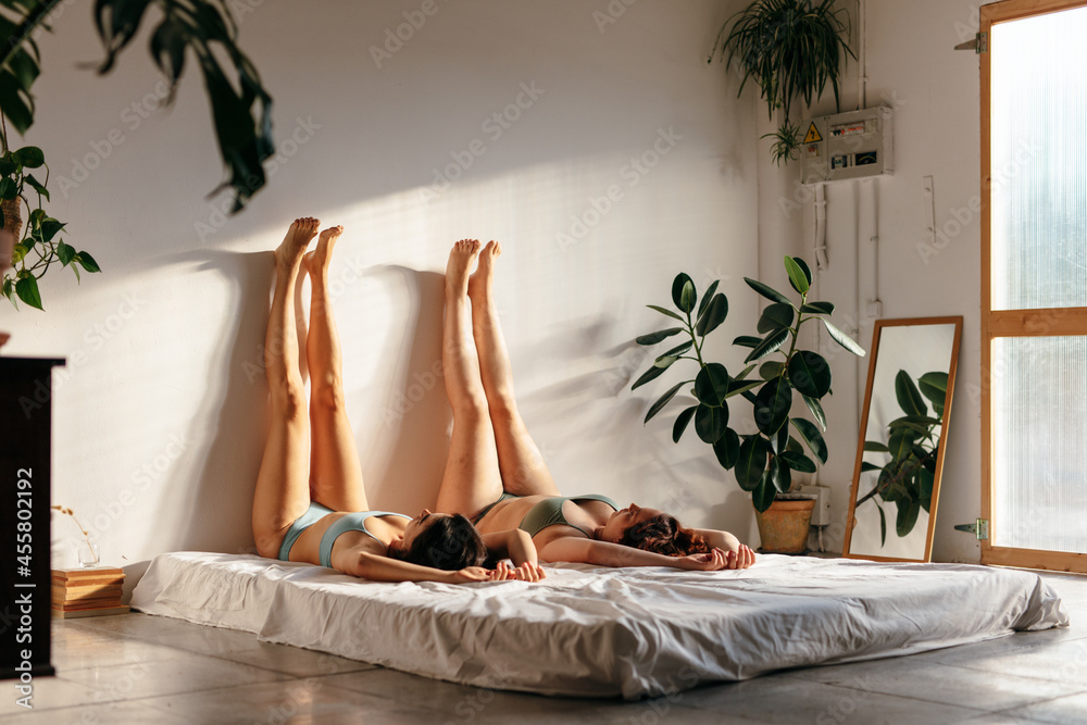 © Marc Bordons/Stocksy - Two girls lying on the bed with their legs up