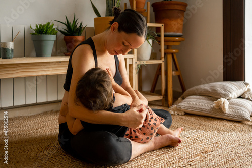 Modern mother feeding her baby at home