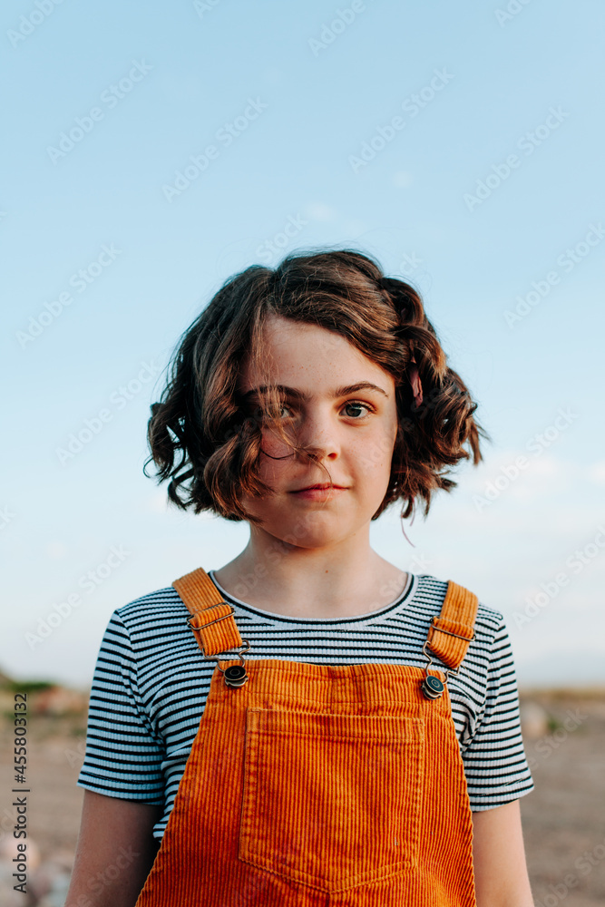 Girl smirking at camera in gold and stripes. Girl smirking at camera in gold and stripes.