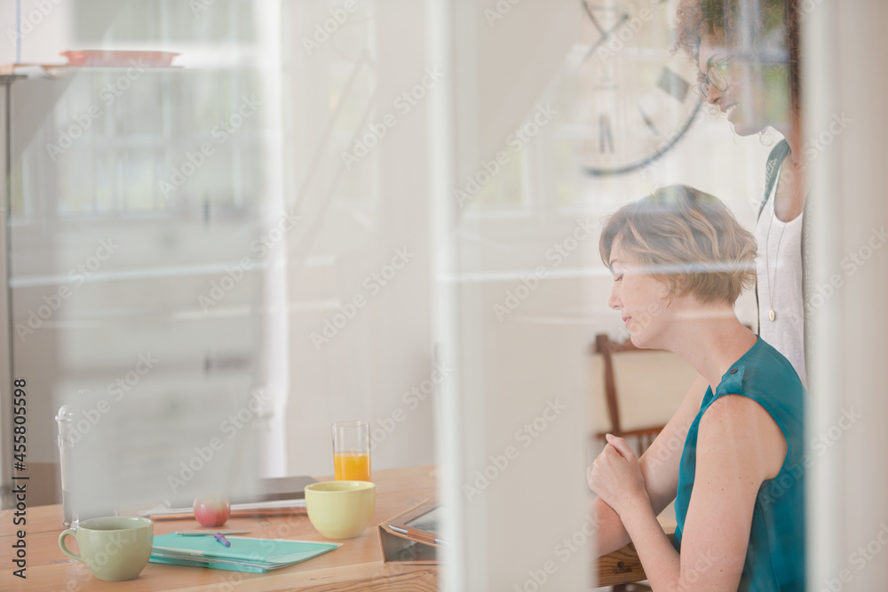 Women talking and smiling in office Women talking and smiling in office