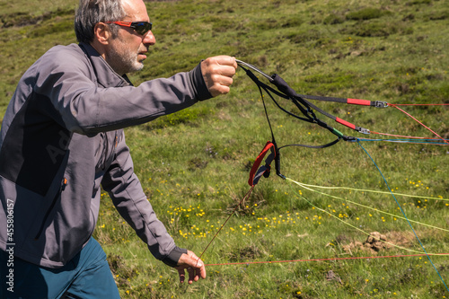 paraglider arranges the lines of his wing