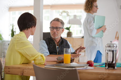 Man and woman sitting in office,smiling and talking