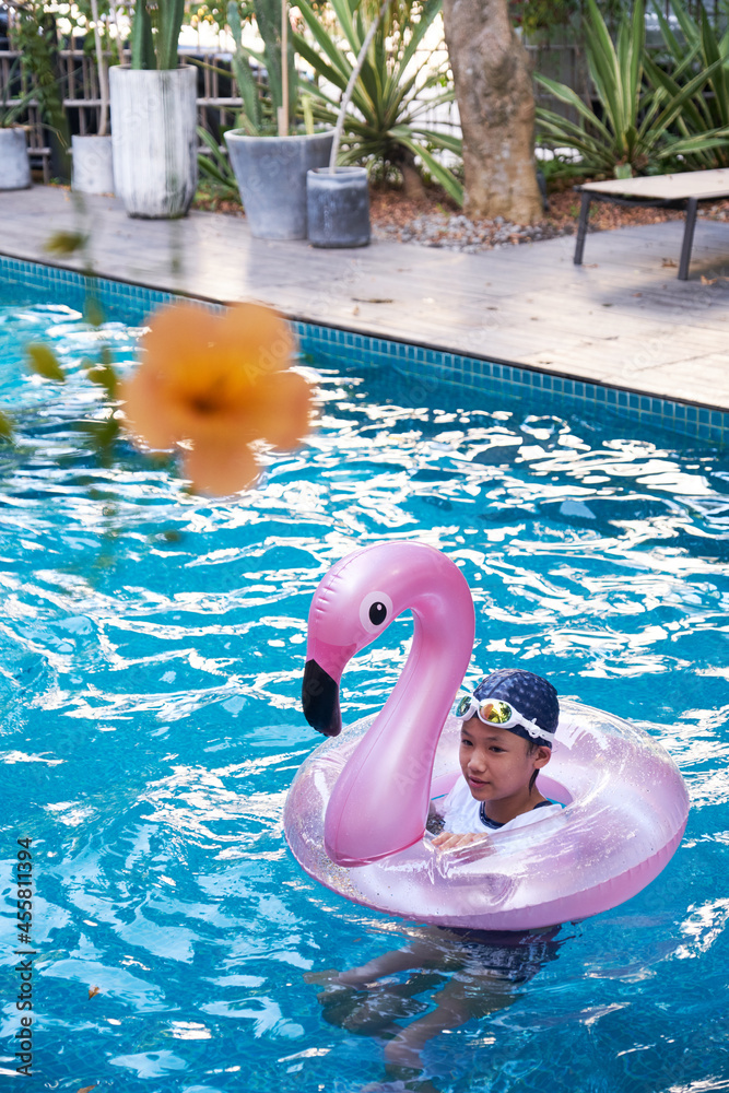 Asian little girl swimming in the pool in summer Stock Photo | Adobe Stock