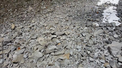 Pan up to a mountain full of stones in the alps