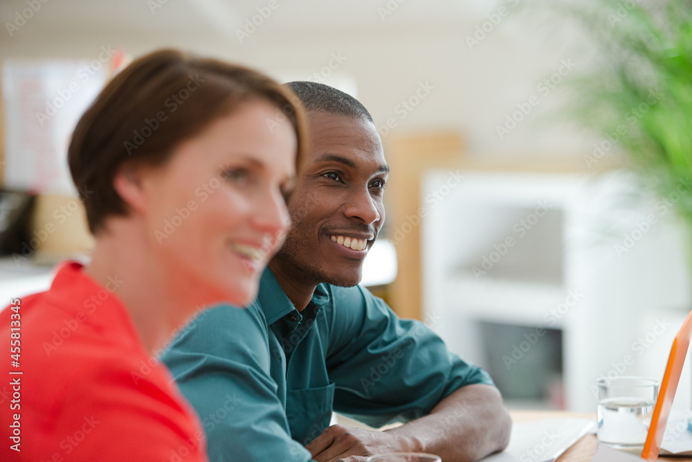 Fototapeta premium Man and woman sitting and smiling in office