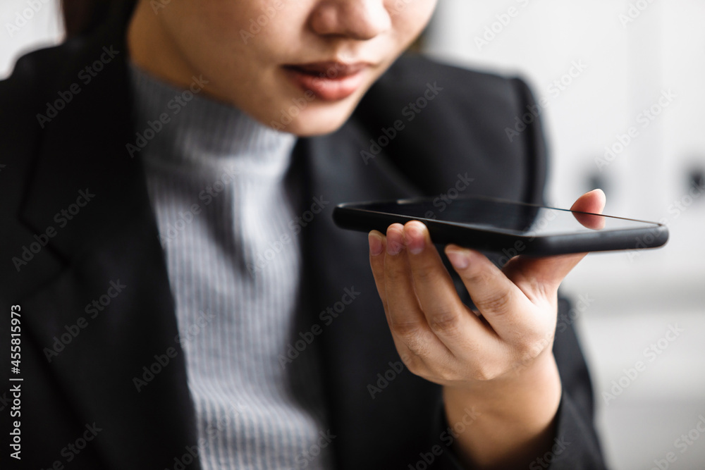 close up of businesswoman recording audio message on mobile phone, using vocal command to virtual assistant for online search, using voice recognition app, sending voice message on social media online close up of businesswoman recording audio message on mobile phone, using vocal command to virtual assistant for online search, using voice recognition app, sending voice message on social media online