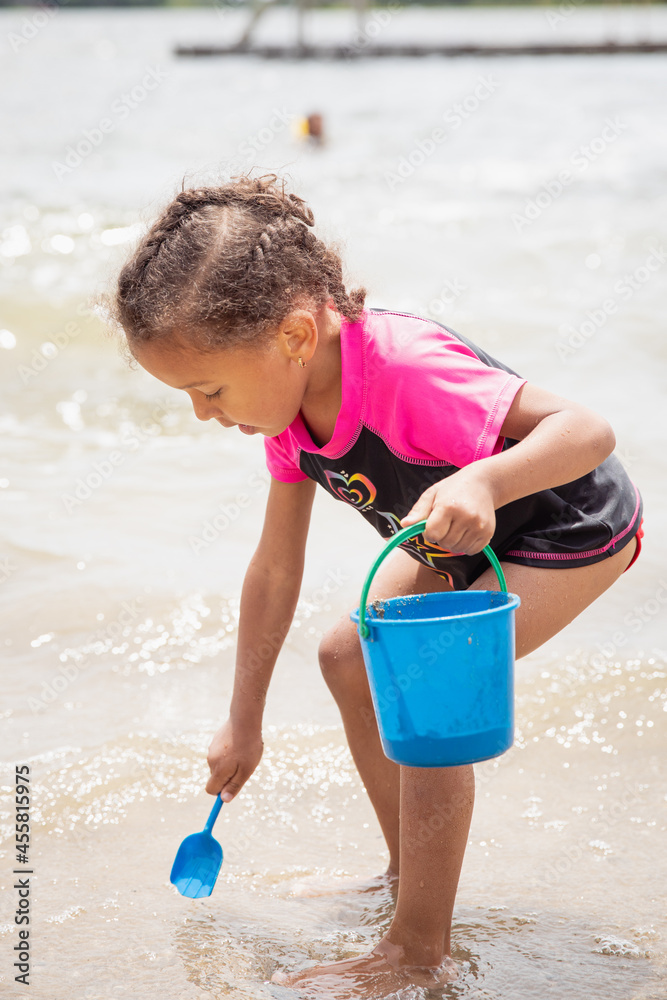 Child playing in the sand and water while at a lake Child playing in the sand and water while at a lake