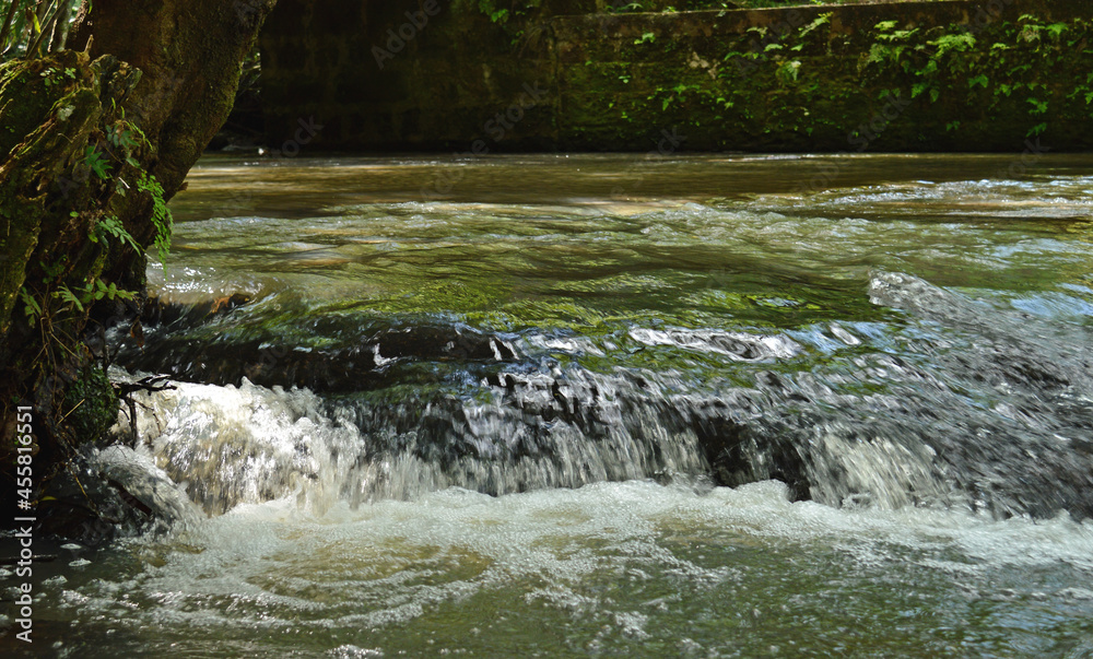 Tiny stream of water flowing through the rocks of a river. Tiny stream of water flowing through the rocks of a river.