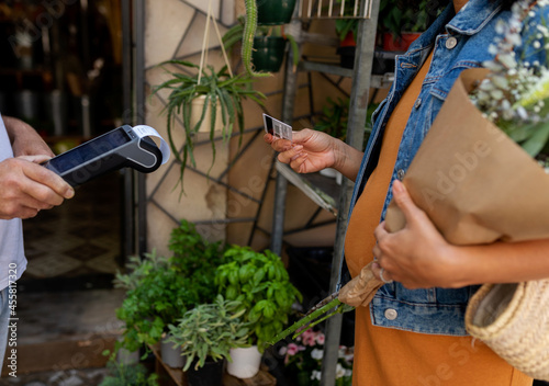 Woman paying with credit card at florist photo