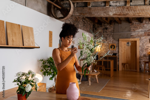 Woman decorating her house with a flowers bouquet