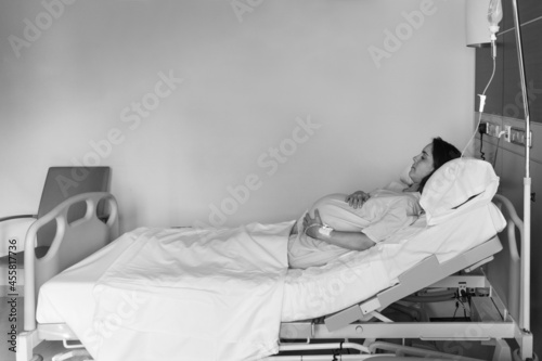 Woman having contractions in hospital room photo