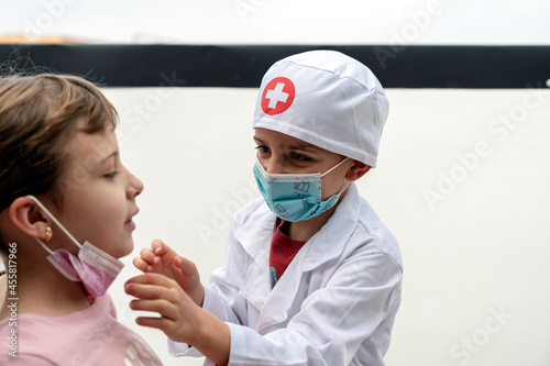 Little brother playing doctor with his sister photo