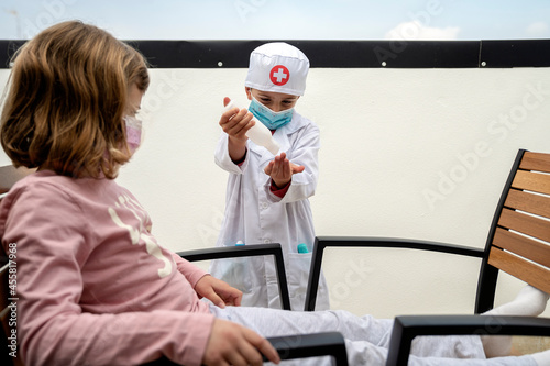 Brother and sister playing doctor while he disinfects his hands photo