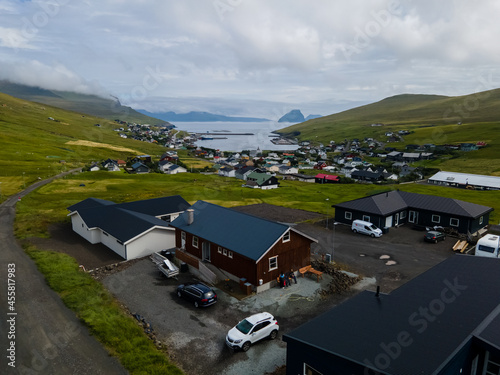 Beautiful aerial view of the town of Miovagur in the Faroe Islands, with its :churchs, grass roofs and colorful Houses in front of the ocean 