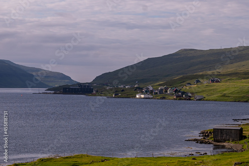 Beautiful aerial view of the town of Miovagur in the Faroe Islands, with its :churchs, grass roofs and colorful Houses in front of the ocean 