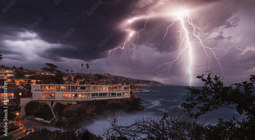 Lightning flashes over a cliff overlooking the ocean Stock Photo ...