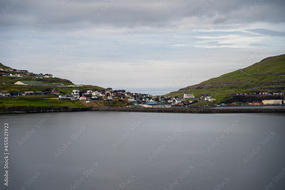 Beautiful aerial view of the town of Miovagur in the Faroe Islands, with its :churchs, grass roofs and colorful Houses in front of the ocean 