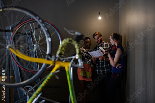 Creative business people working behind bicycle wheel in office