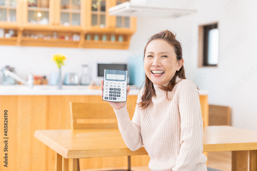 電卓を持つシニア女性　笑顔