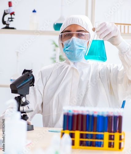 Young chemist student working in lab on chemicals