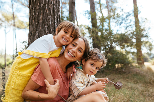 Loving mother with children embracing in countryside woods
 photo