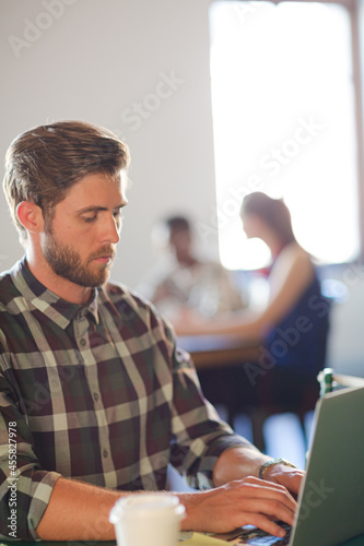 Casual businessman using laptop in office