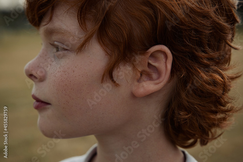 Ginger boy in nature in summer photo