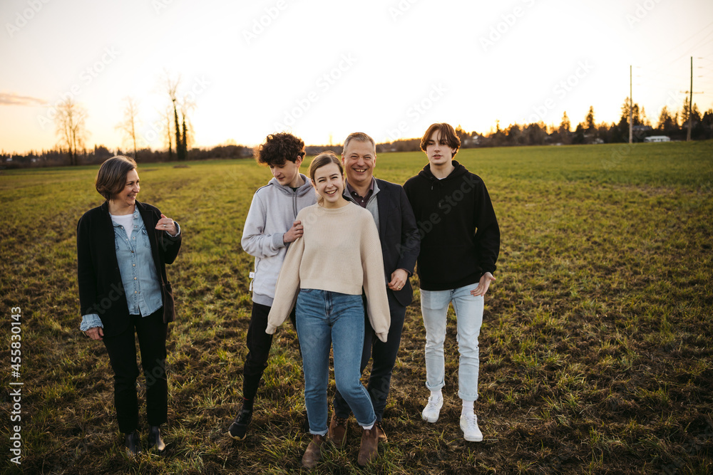 Laughing family with parents and teens outside together. Laughing family with parents and teens outside together.