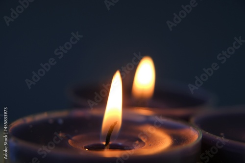 Burning candles.Candle flame. blue candles in the dark.Religion symbol. Candles background.Blue candles on dark blue background. 