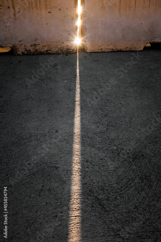 A fine line of sunlight on the concrete.