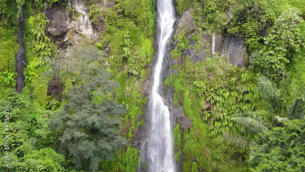 Wonderful nature. Flying back away from a high waterfall in a tropical forest. Java, Indonesia Wonderful nature. Flying back away from a high waterfall in a tropical forest. Java, Indonesia