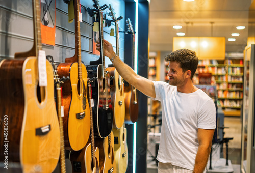 Man choosing guitar in shop