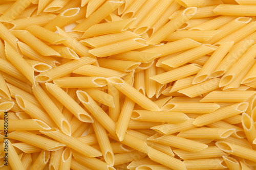 Uncooked penne pasta as background