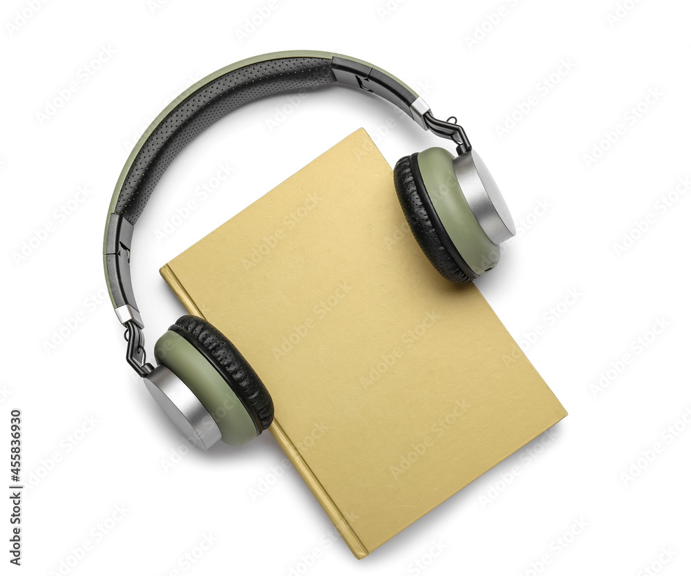 Modern headphones with book on white background Modern headphones with book on white background