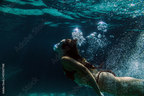 Woman swimming underwater photo