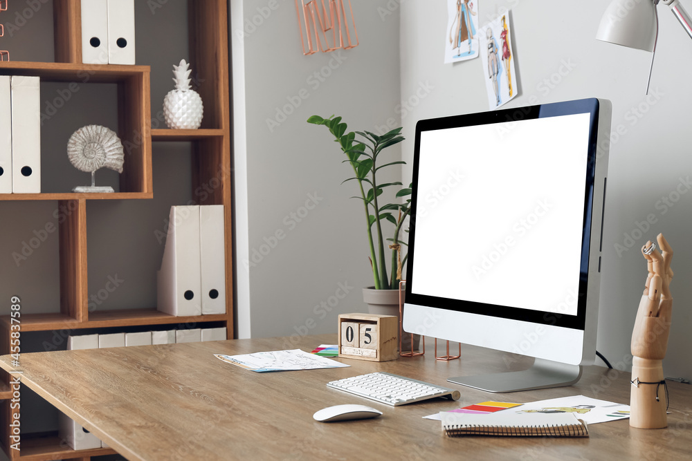 Modern workplace with computer near light wall Modern workplace with computer near light wall