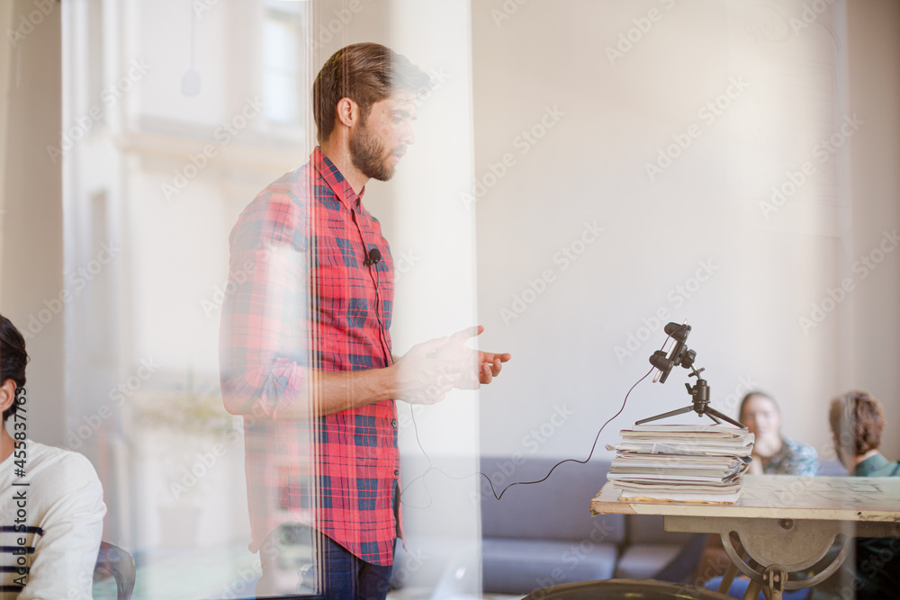 Creative businessman posing photograph for coworker instant camera in office Creative businessman posing photograph for coworker instant camera in office