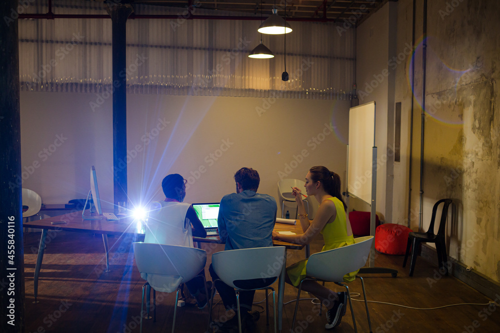 Lens flare over creative business people working in office