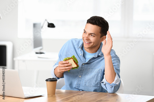 Young man with tasty sandwi...