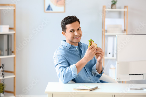 Young man with tasty sandwi...