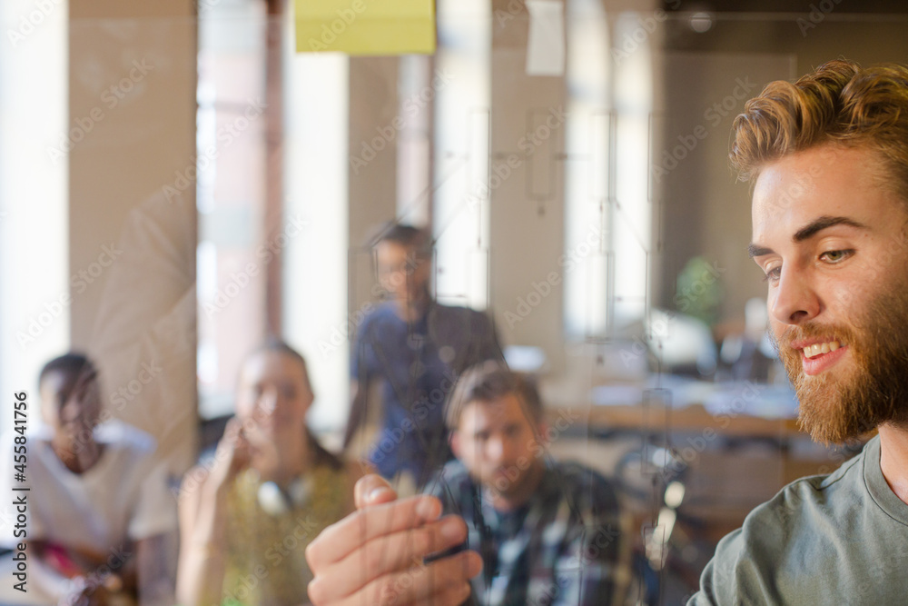 Obraz premium Casual businessman explaining diagram on glass in meeting