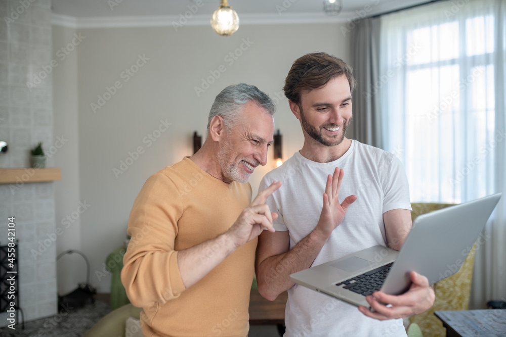 Fototapeta premium Two men having a video call and looking excited