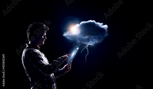 Lightning against dark background and businessman . Mixed media © Sergey Nivens